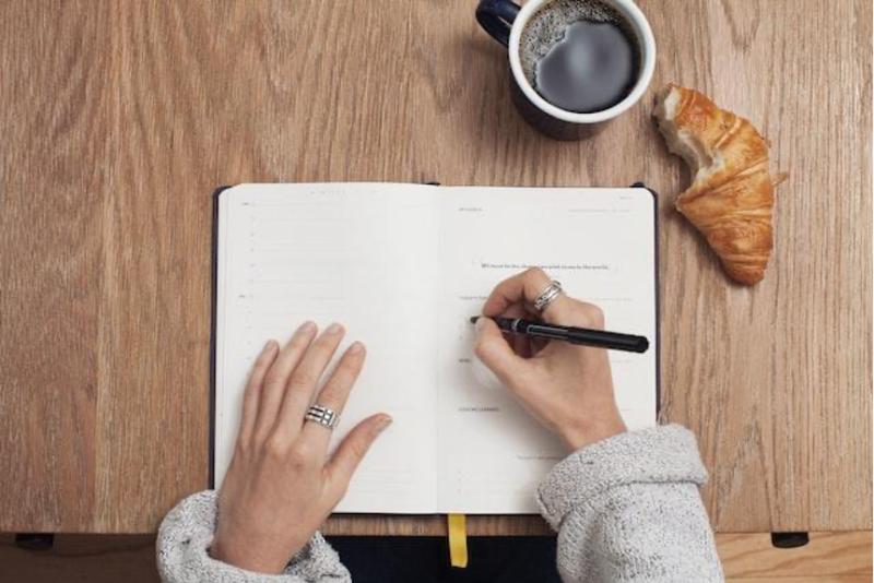 A person writing a checklist before signing a rental lease in Florida.